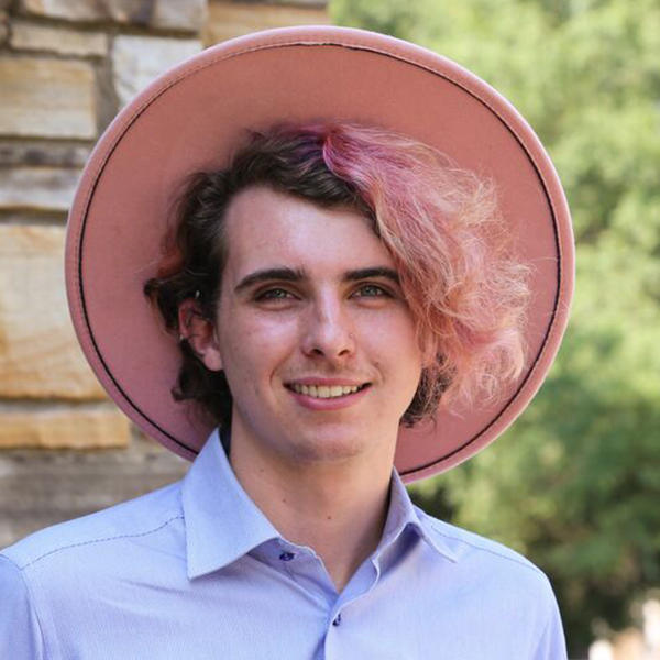 a young person with a pink hat and a pink streak in their hair