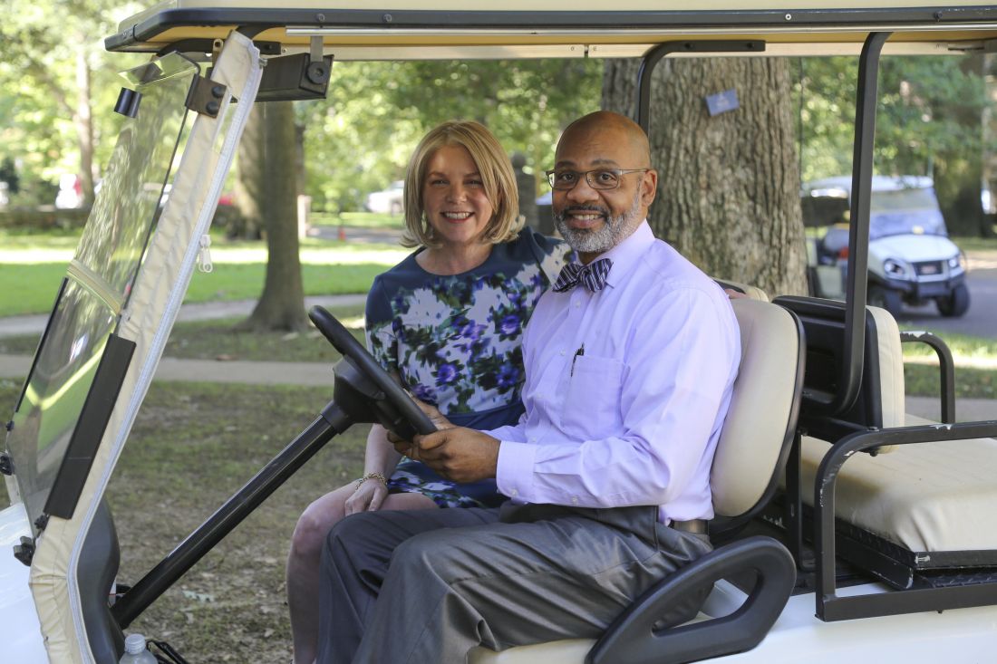 president hass and dean wiggington on a golf cart
