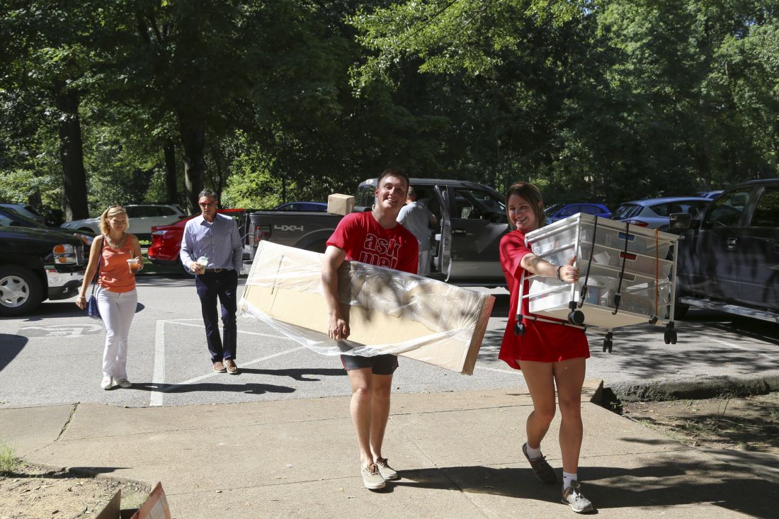 students carrying dorm furniture
