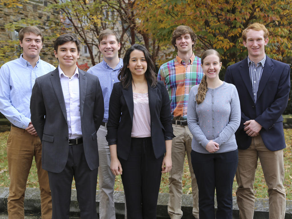 a diverse group of male and female students standing in professional attire