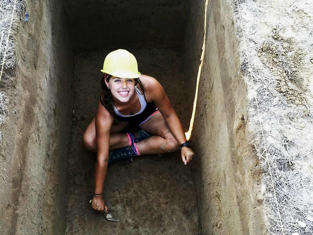 a young white female student on an archaeological dig site