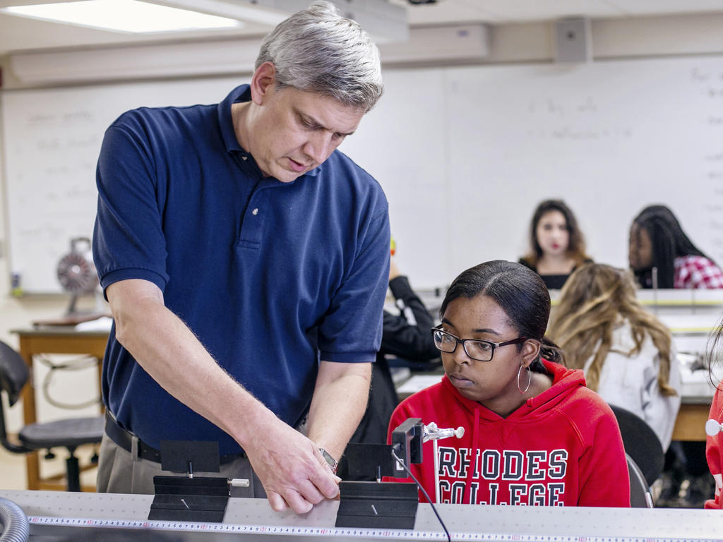 an older white male professor assists a young African American woman
