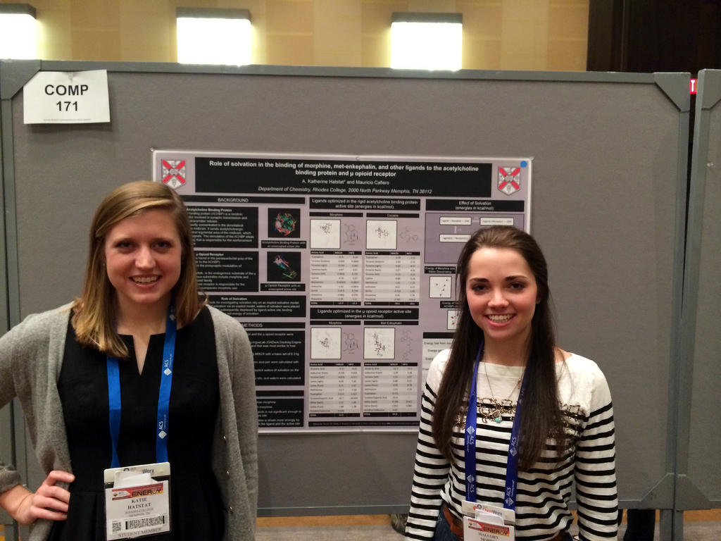 two female students smiling next to their research poster