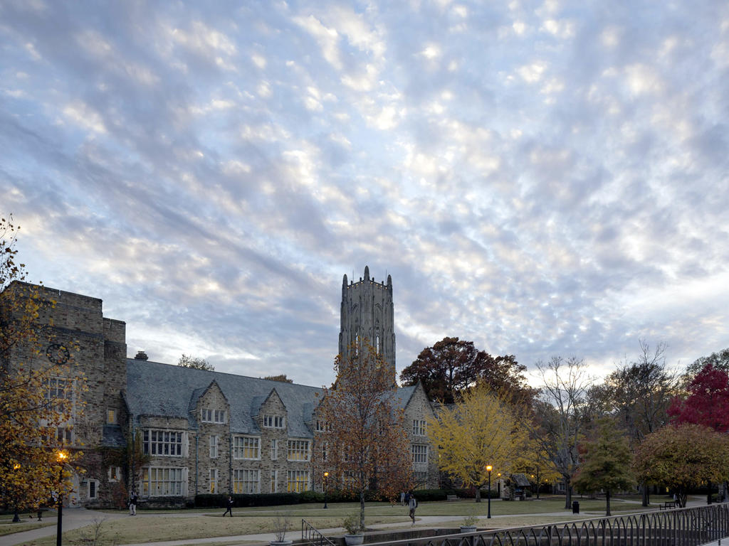 collegiate gothic building with blue sky bursting with clouds