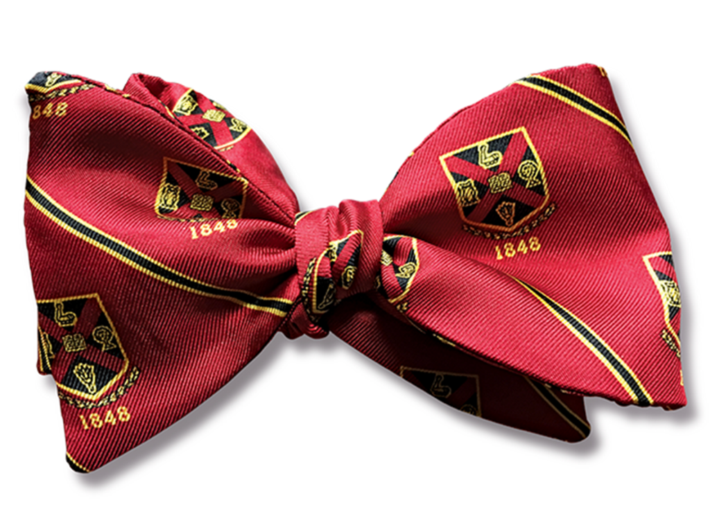 a red bow tie with the Rhodes College crest patterned on it