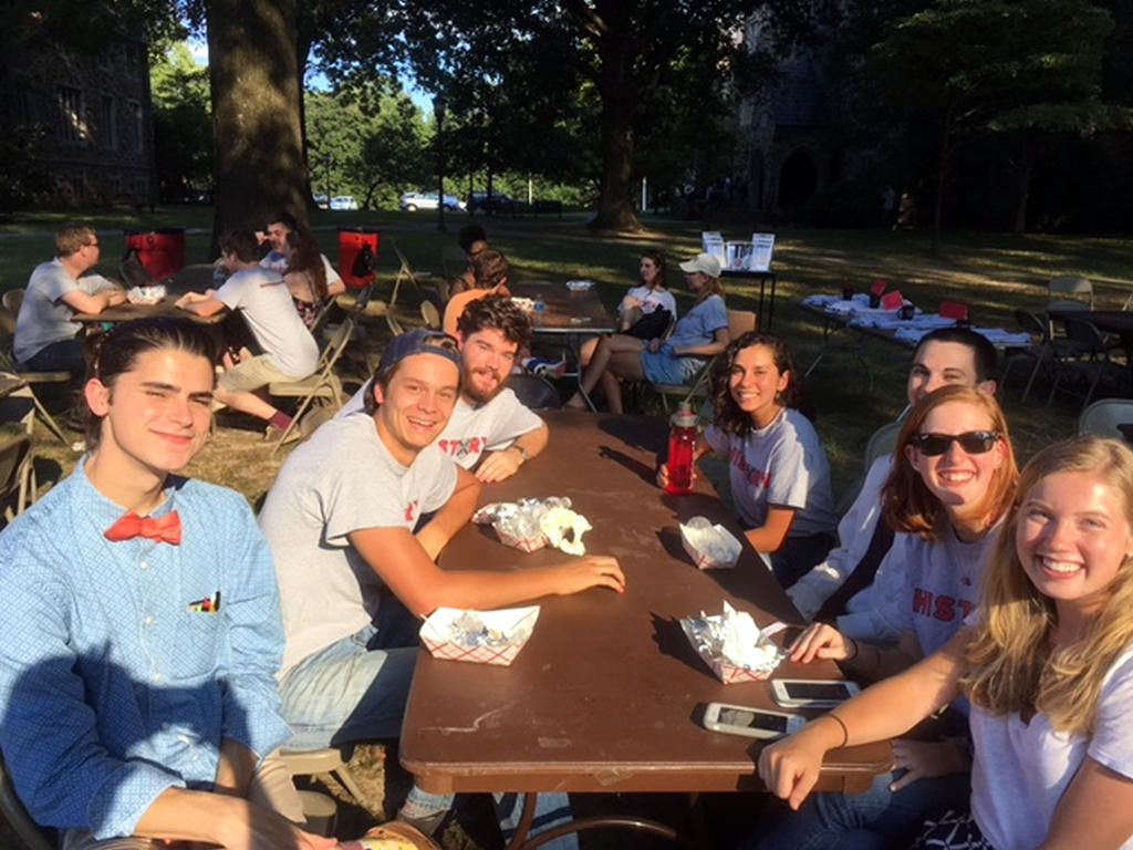 a diverse group of male and female students smiling at a picnic table