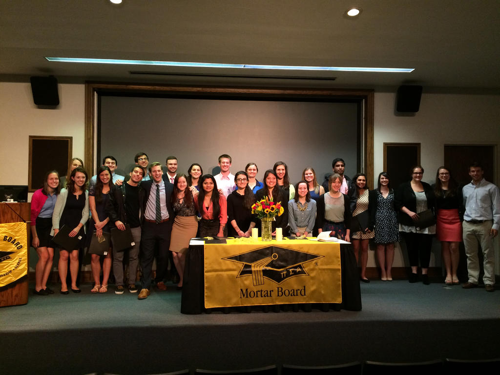 a large group of students in front of a yellow, Mortar Board banner