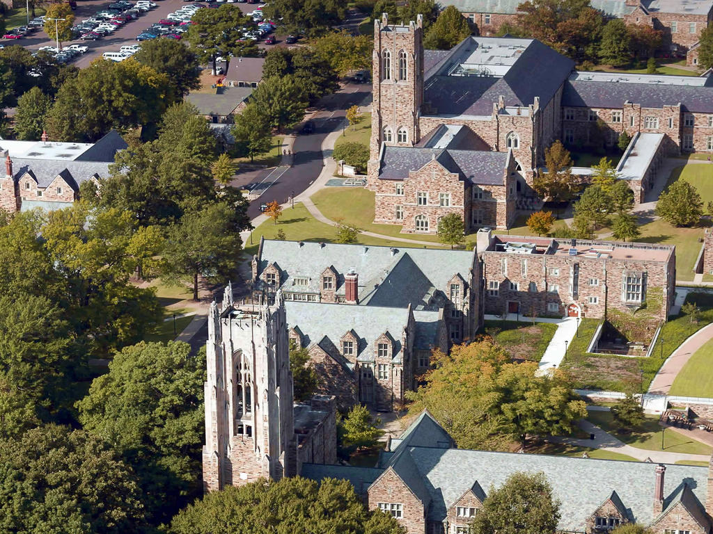 An aerial view of stone academic buildings and their respective quadrangles