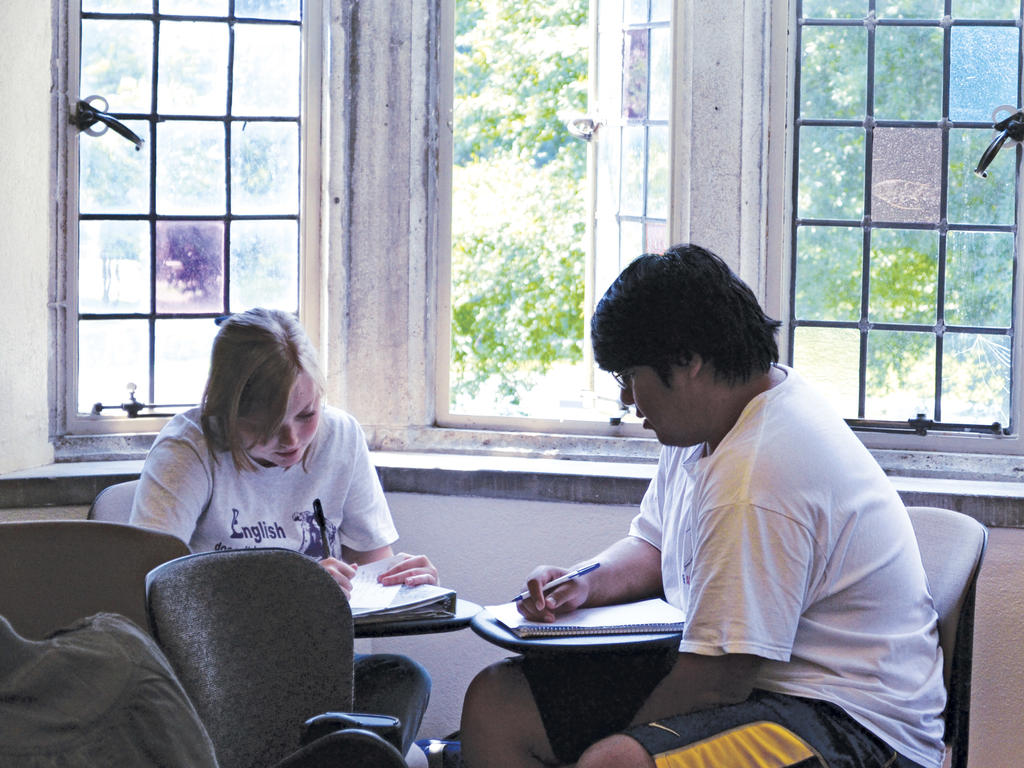 Two students writing in a classroom 