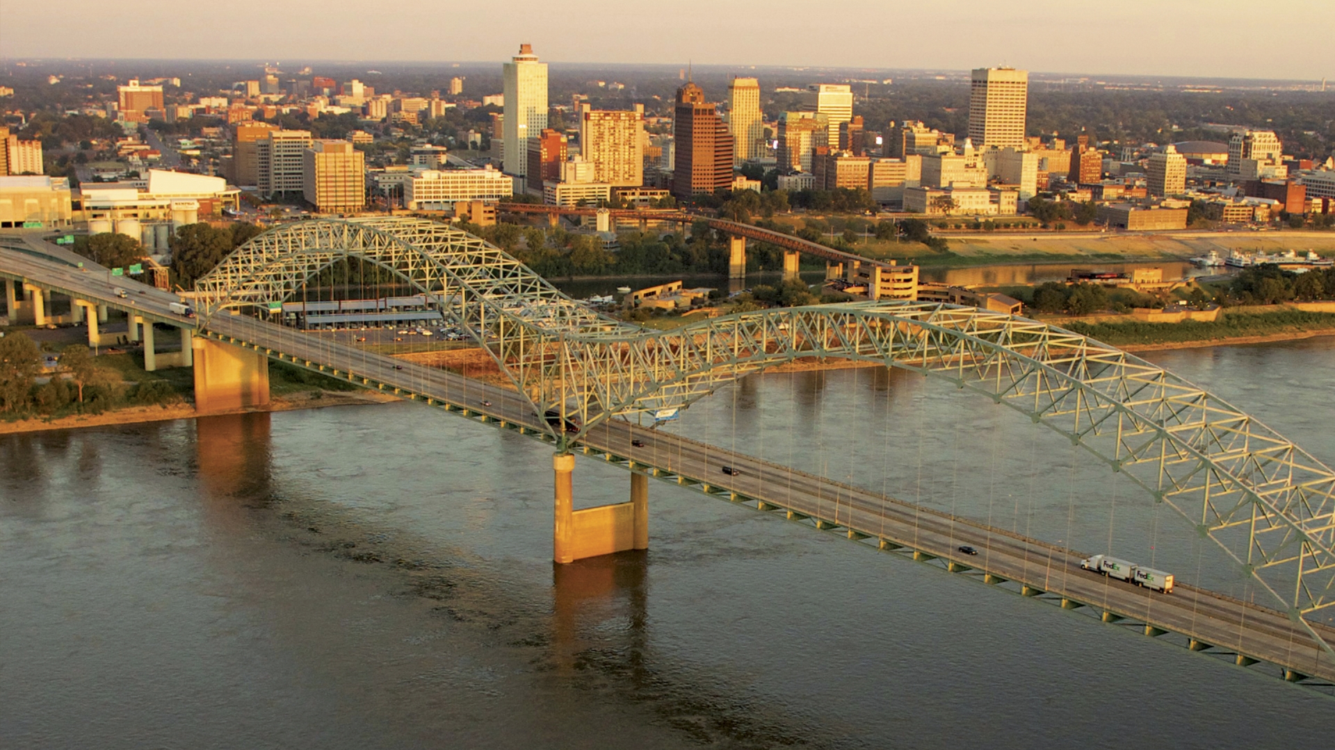 The skyline of Memphis seen from above the distinctive M shaped bridge over the Mississippi river.