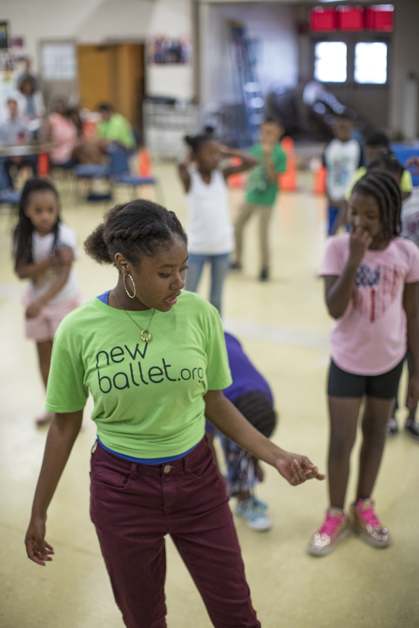 A female student shows dance steps to a group of children