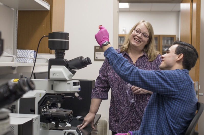A professor and her student examine a lab specimen.