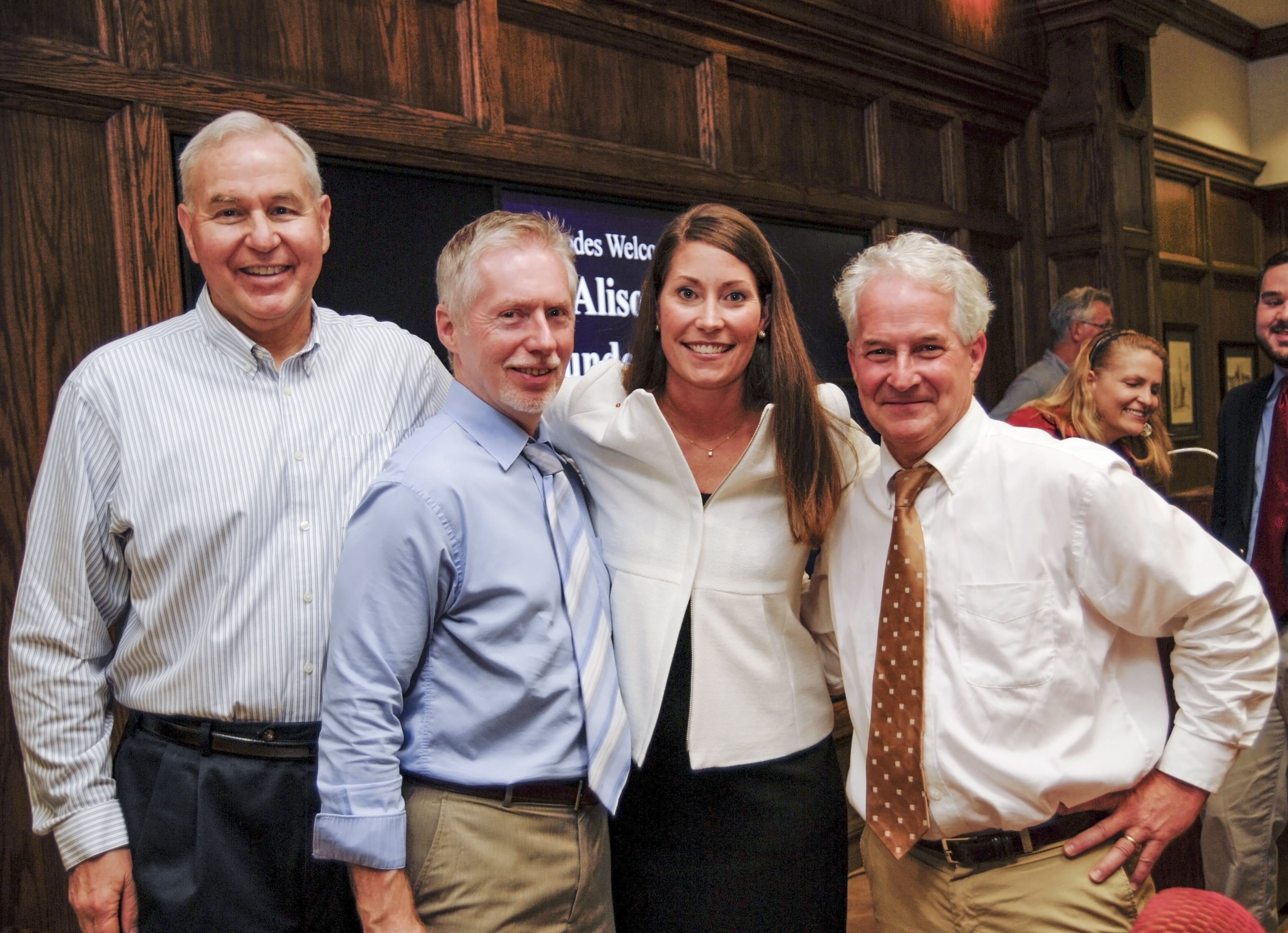 Three male professors with a young woman