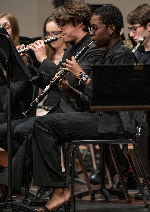 a woman plays a reed instrument in the orchestra