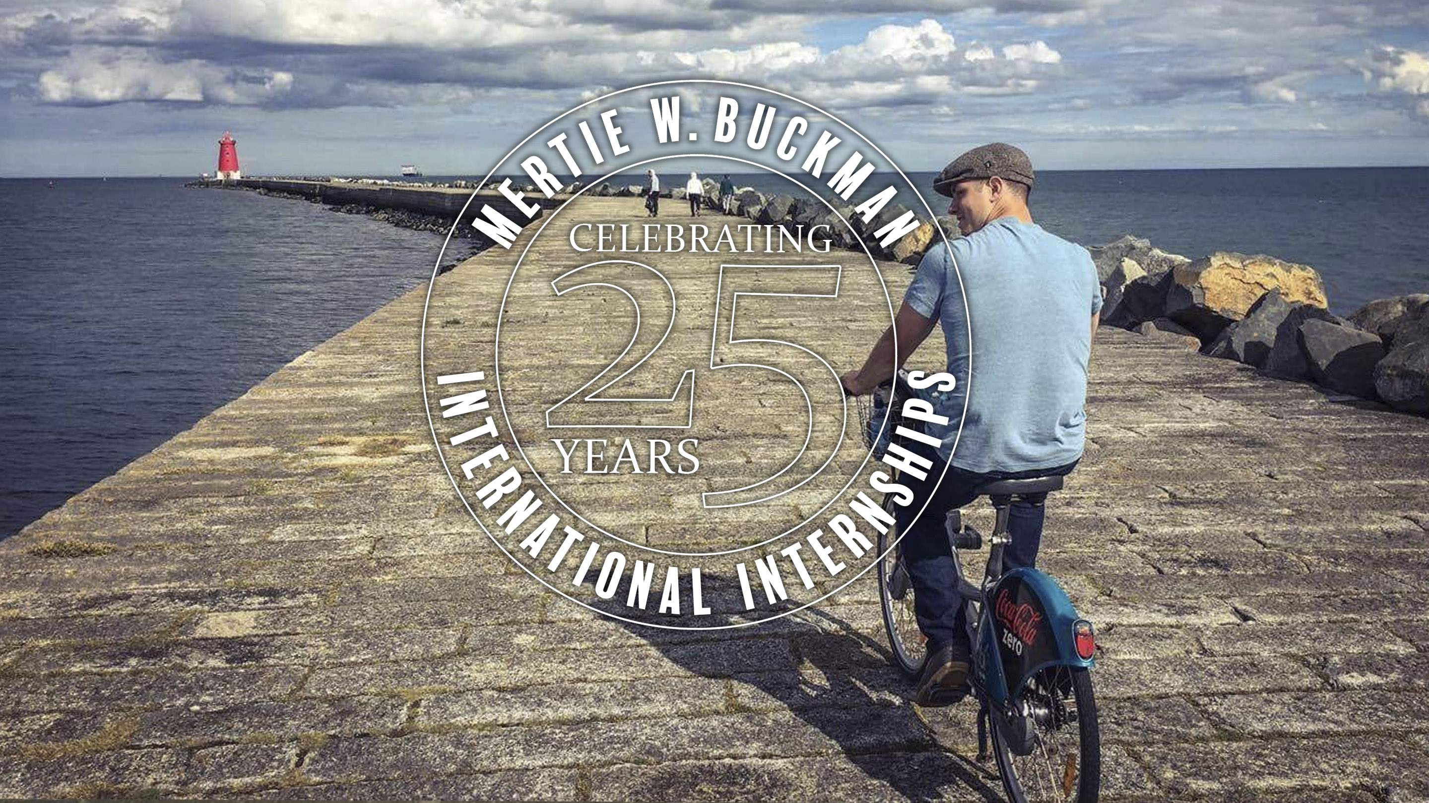 a young man bikes on a pier leading to the ocean