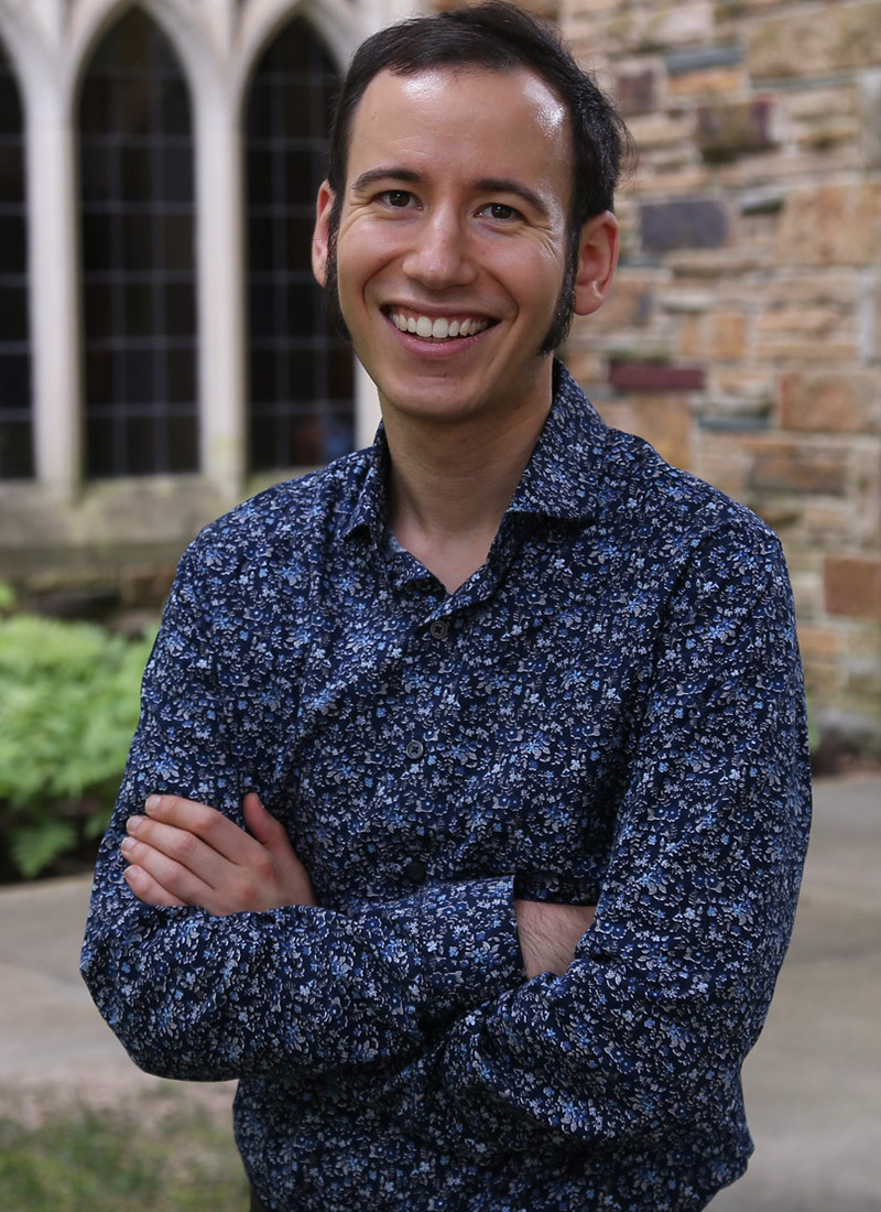 a man with dark hair smiles at the camera
