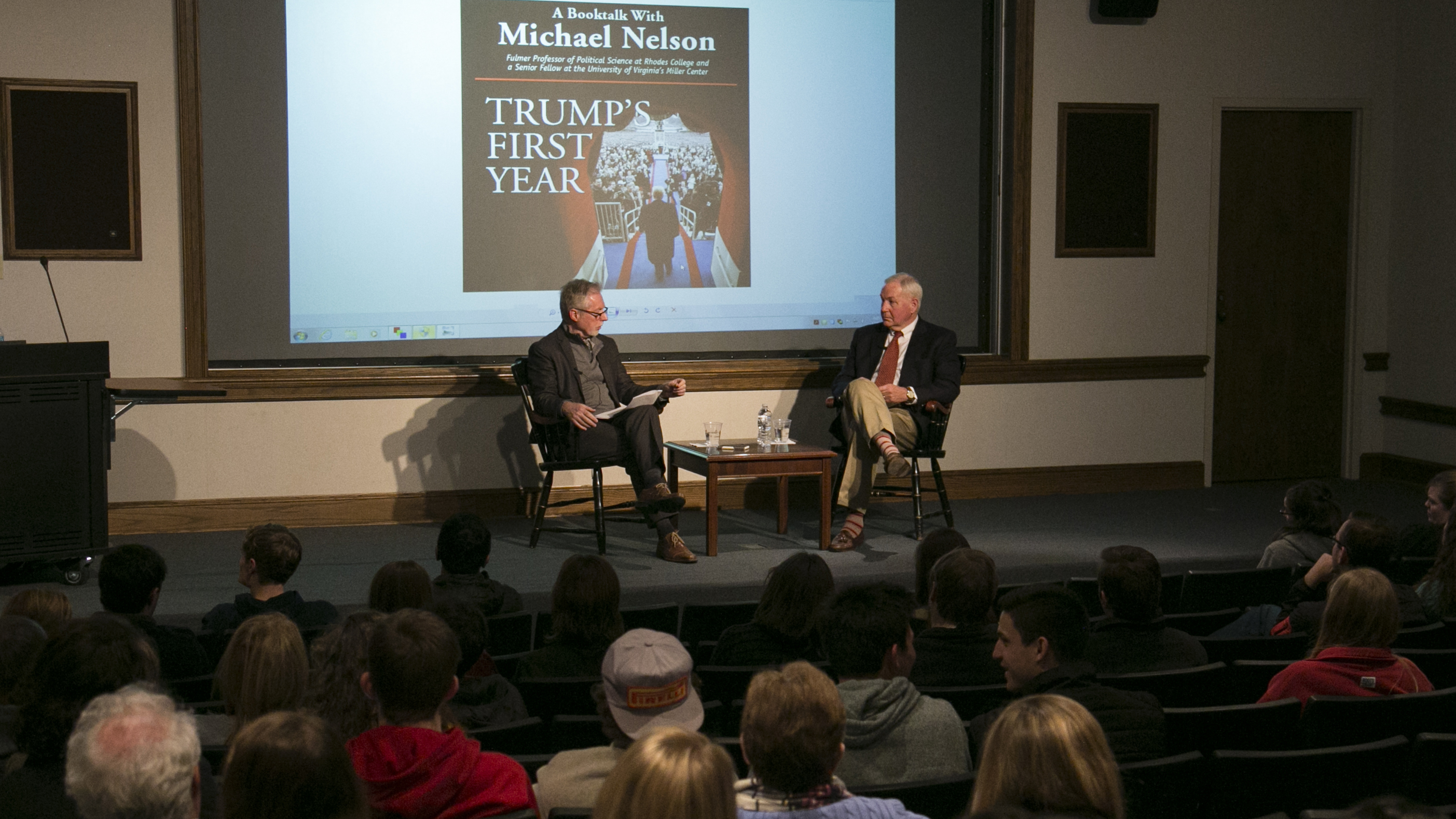 two professors talk on a stage