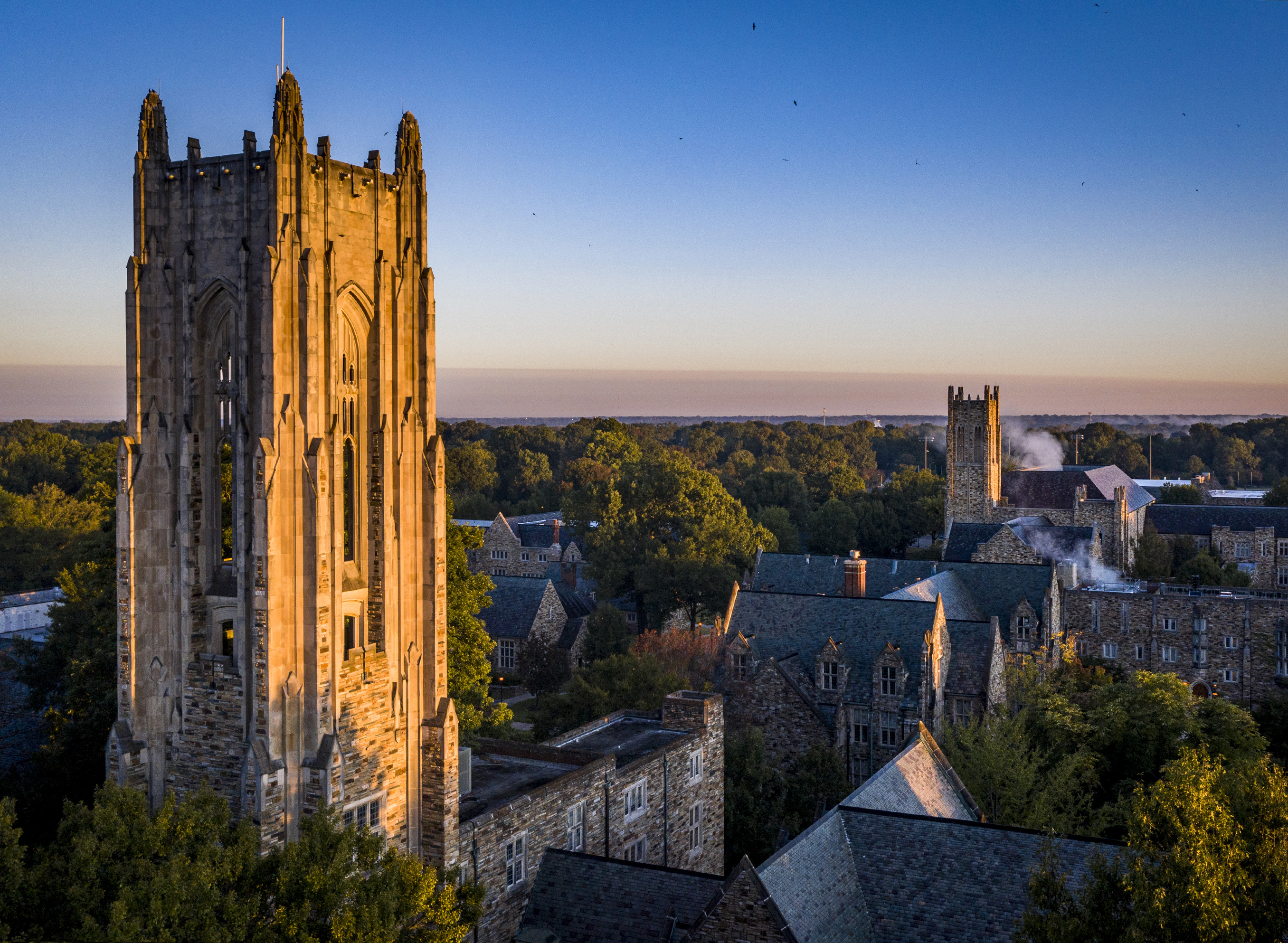a tall Collegiate Gothic tower surrounded by stone buildings