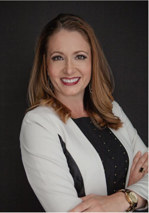 a woman in a white suit with long brown hair