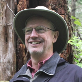 a man with glasses wearing a hat