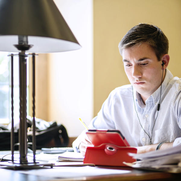 a young man looks at a laptop