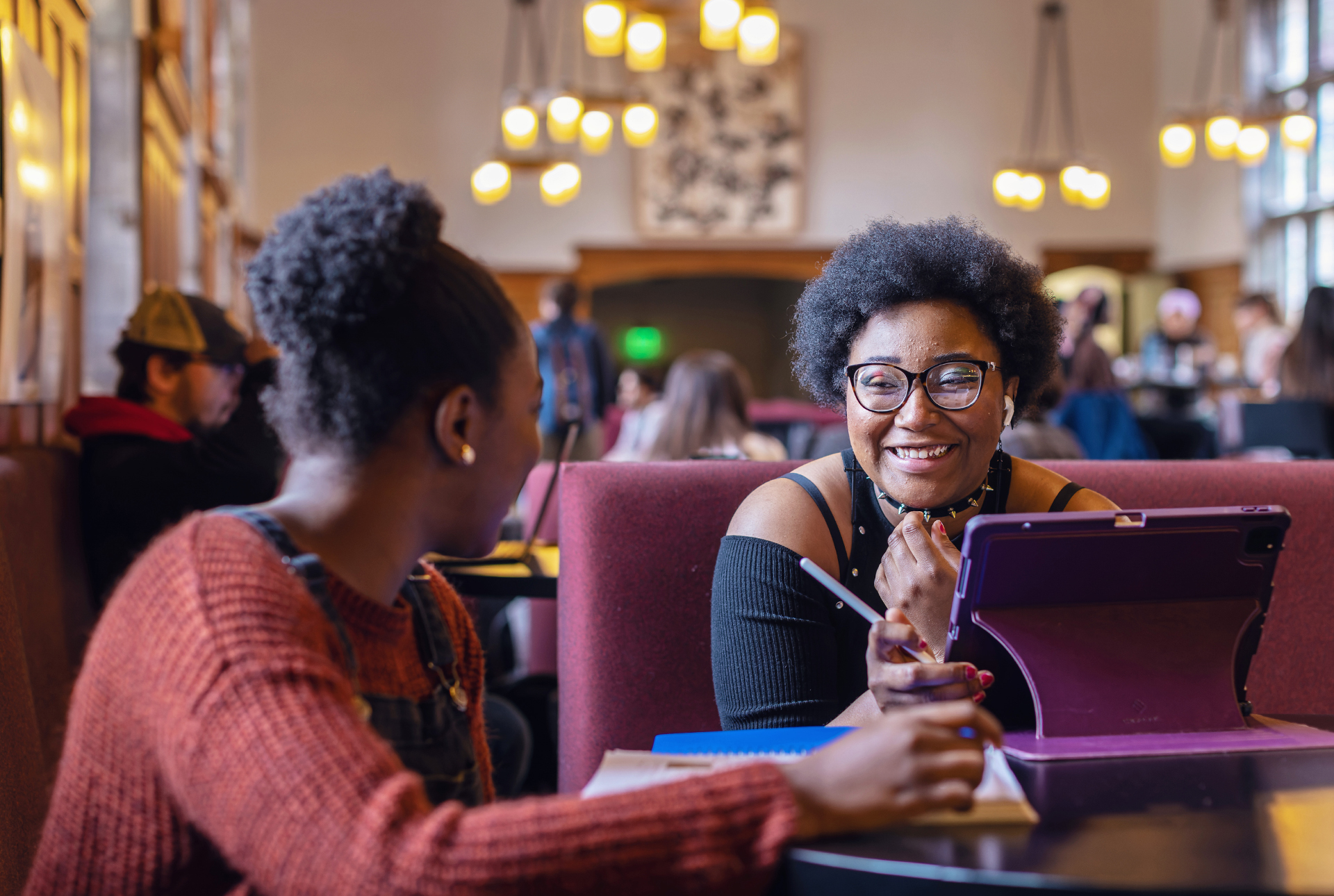 two young African American women work at a table with laptops