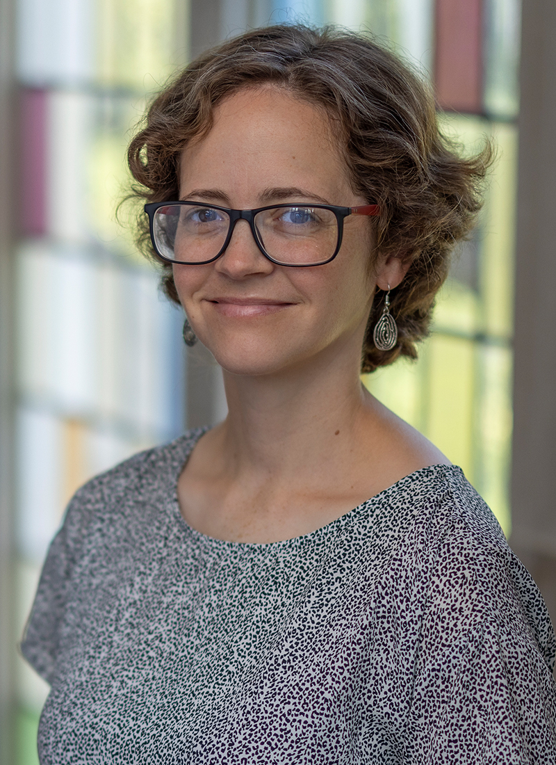 a young woman with short hair and glasses