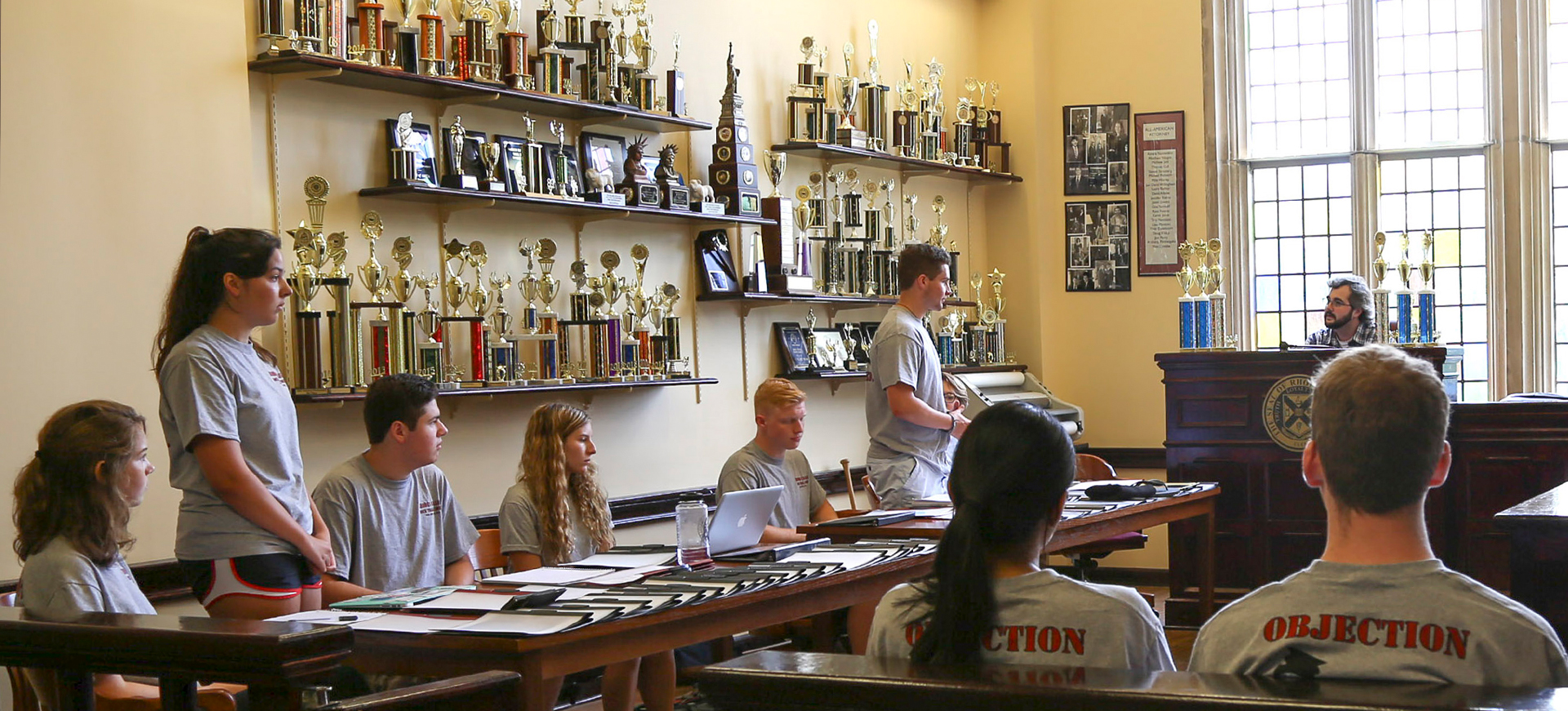 students rehearse a trial in a room with trophies