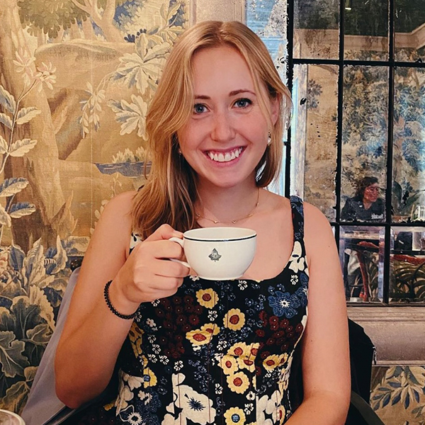 a young woman holds a tea cup