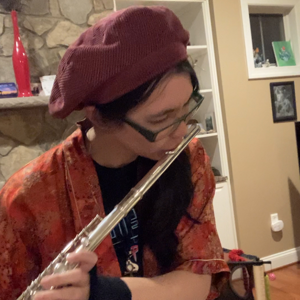 a young woman plays a flute