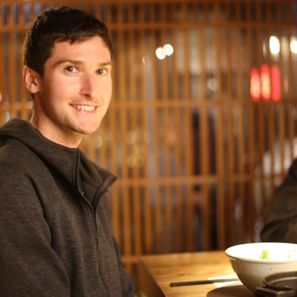 a young man smiles at the camera