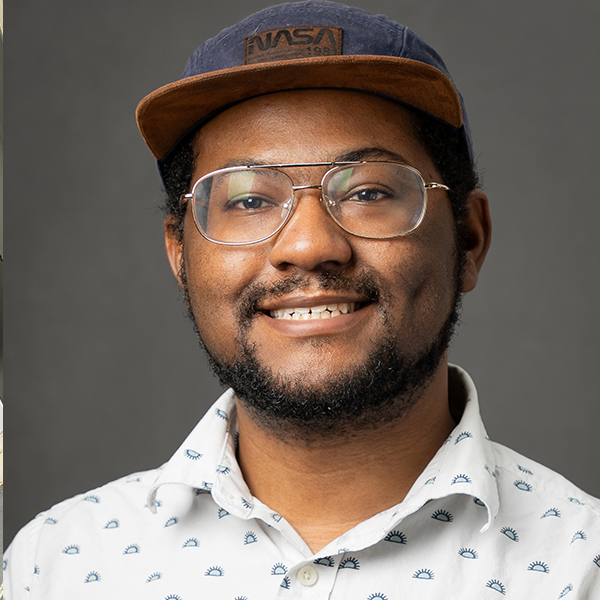 a young African American man in a baseball hat