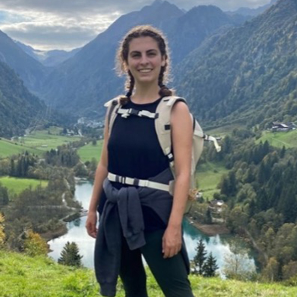 a young woman with mountains in the background