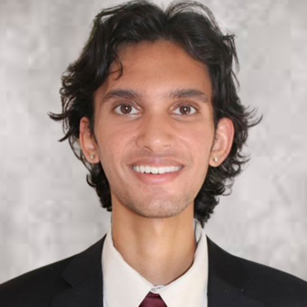 Parth Sinojia, a young man with dark hair smiles at the camera