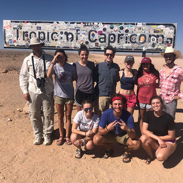 a group of students in front of a Tropic of Capricorn sign