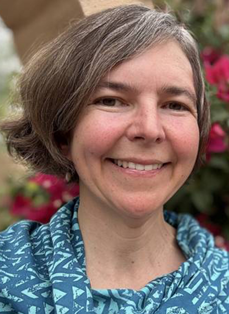 a woman with short hair smiles at the camera