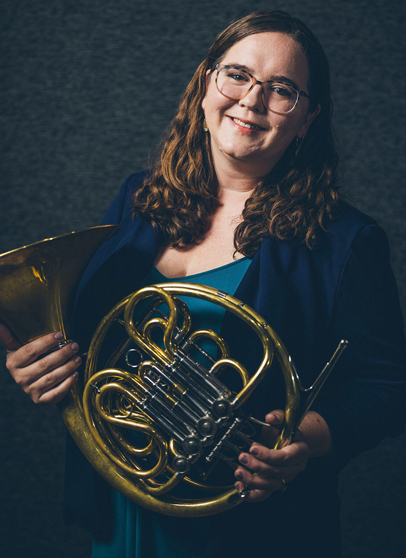 a woman holding a French horn