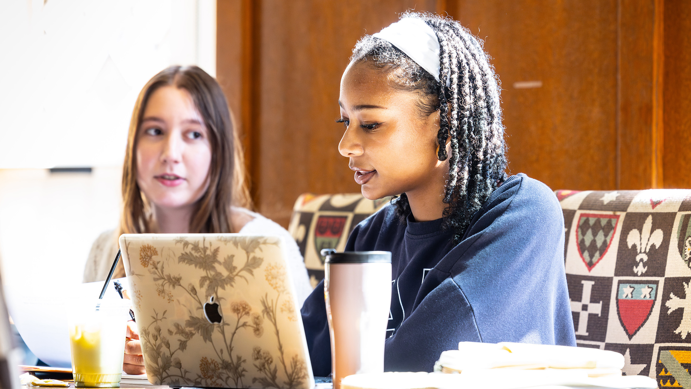 two students look at a laptop