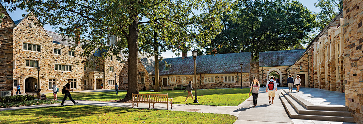 a wide shot of a quad surrounded by Gothic stone buildings