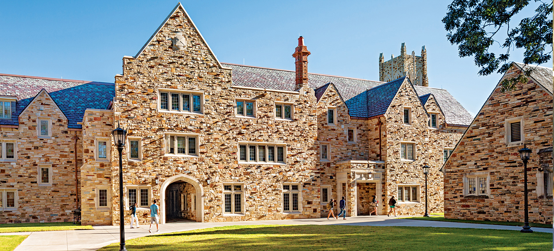 a student walks in front of a Gothic stone building