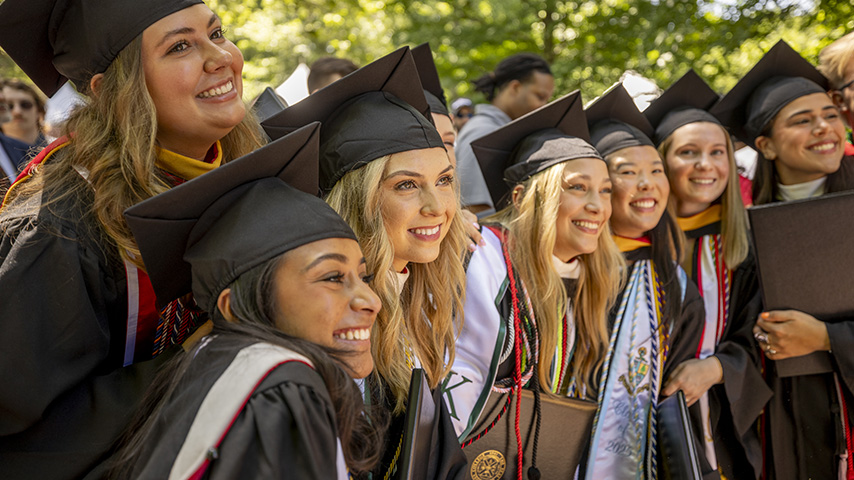 a group of students smile at Commencement