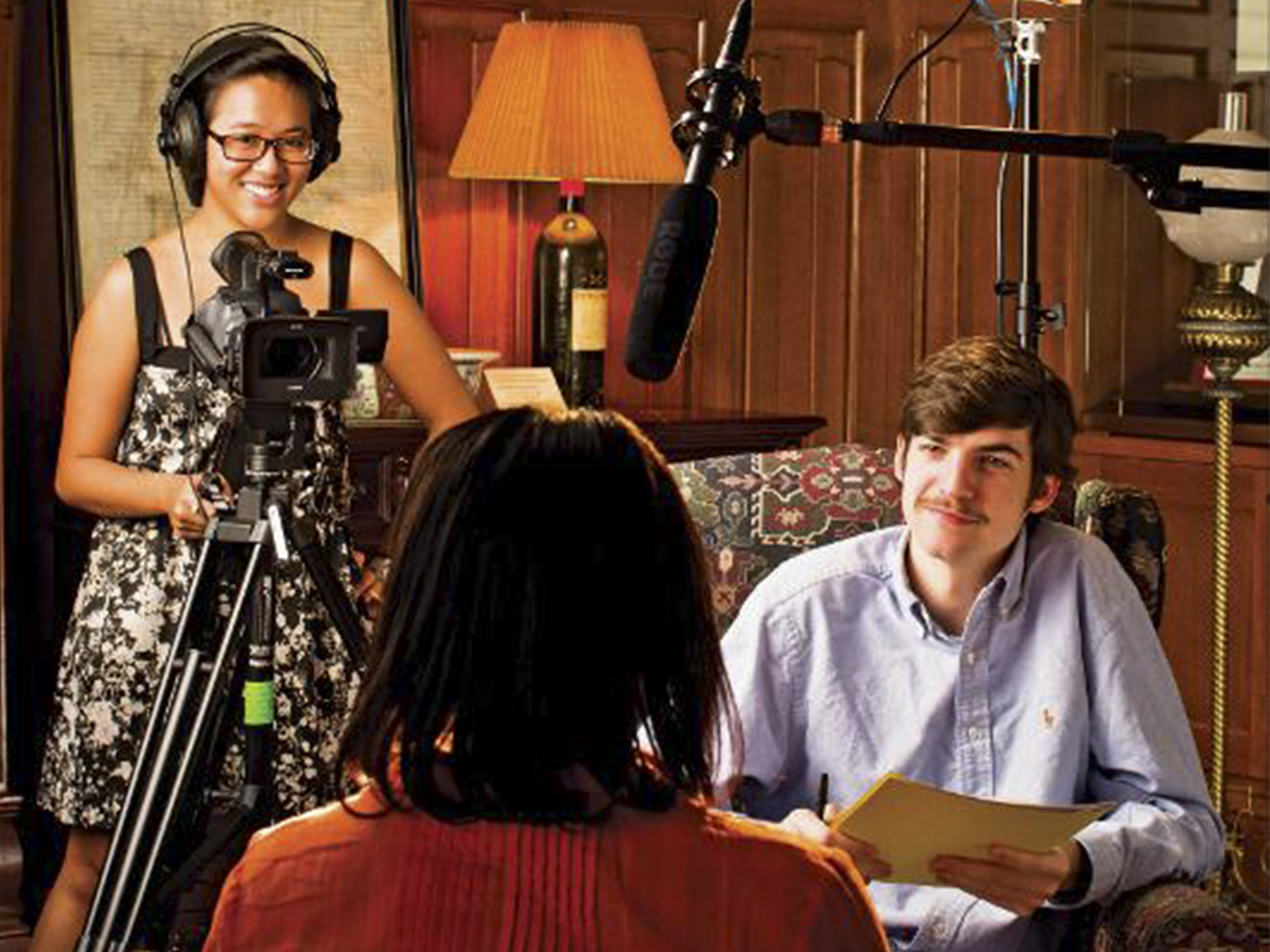 A man and woman interview a subject on camera.