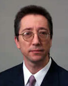 a man with short dark hair and glasses