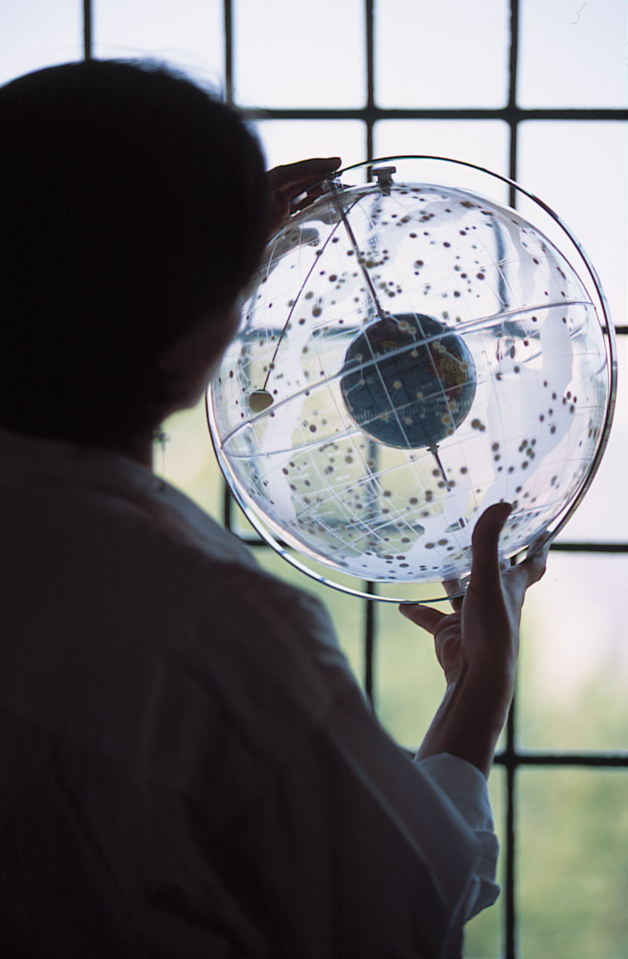 a student examining a clear globe