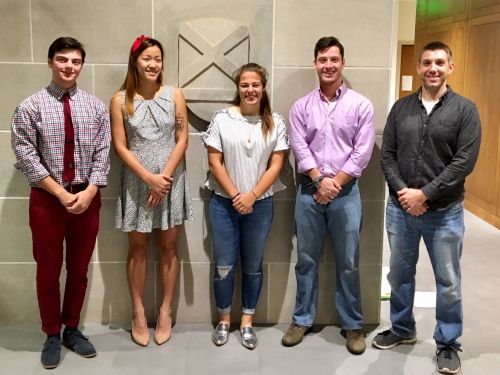 students and a professor in a hallway