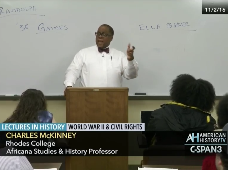 a professor lectures in front of a whiteboard