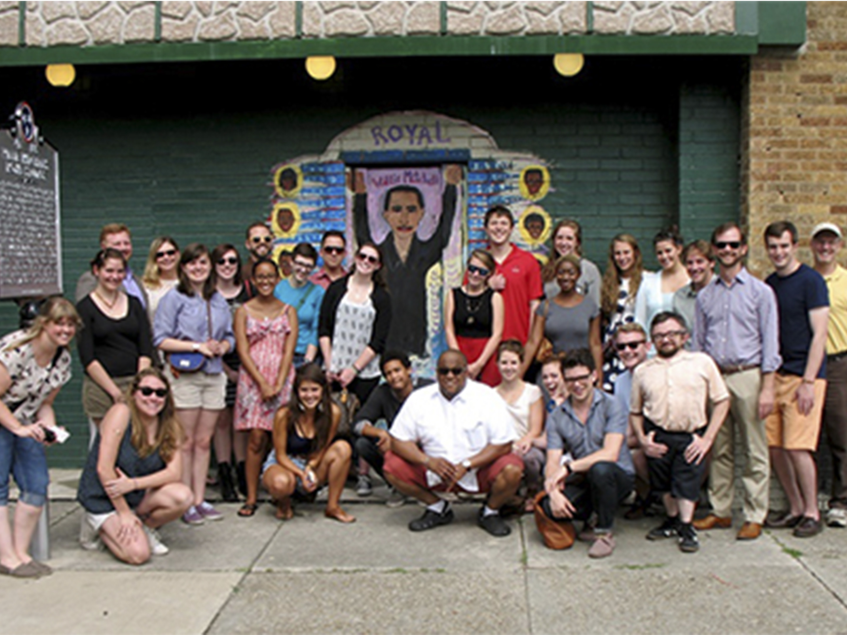 A group of students gathers in front of an old theater.