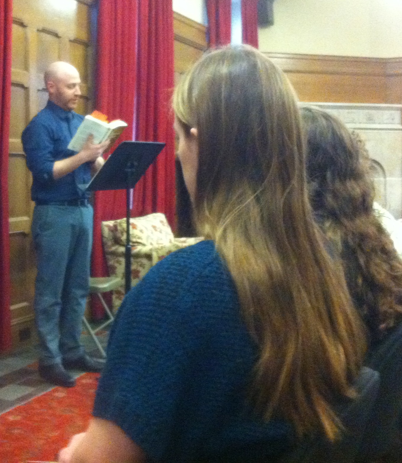 a male professor gives a reading in front of a student audience