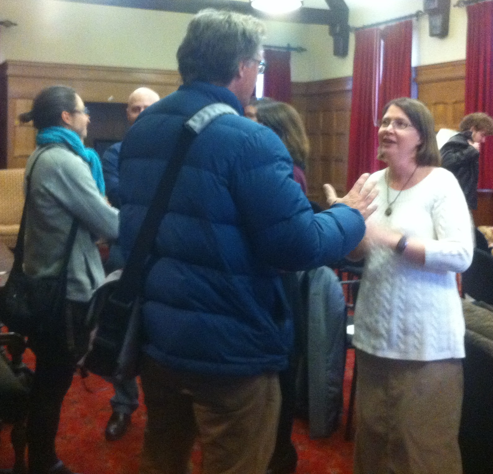 one male and two female professors talk