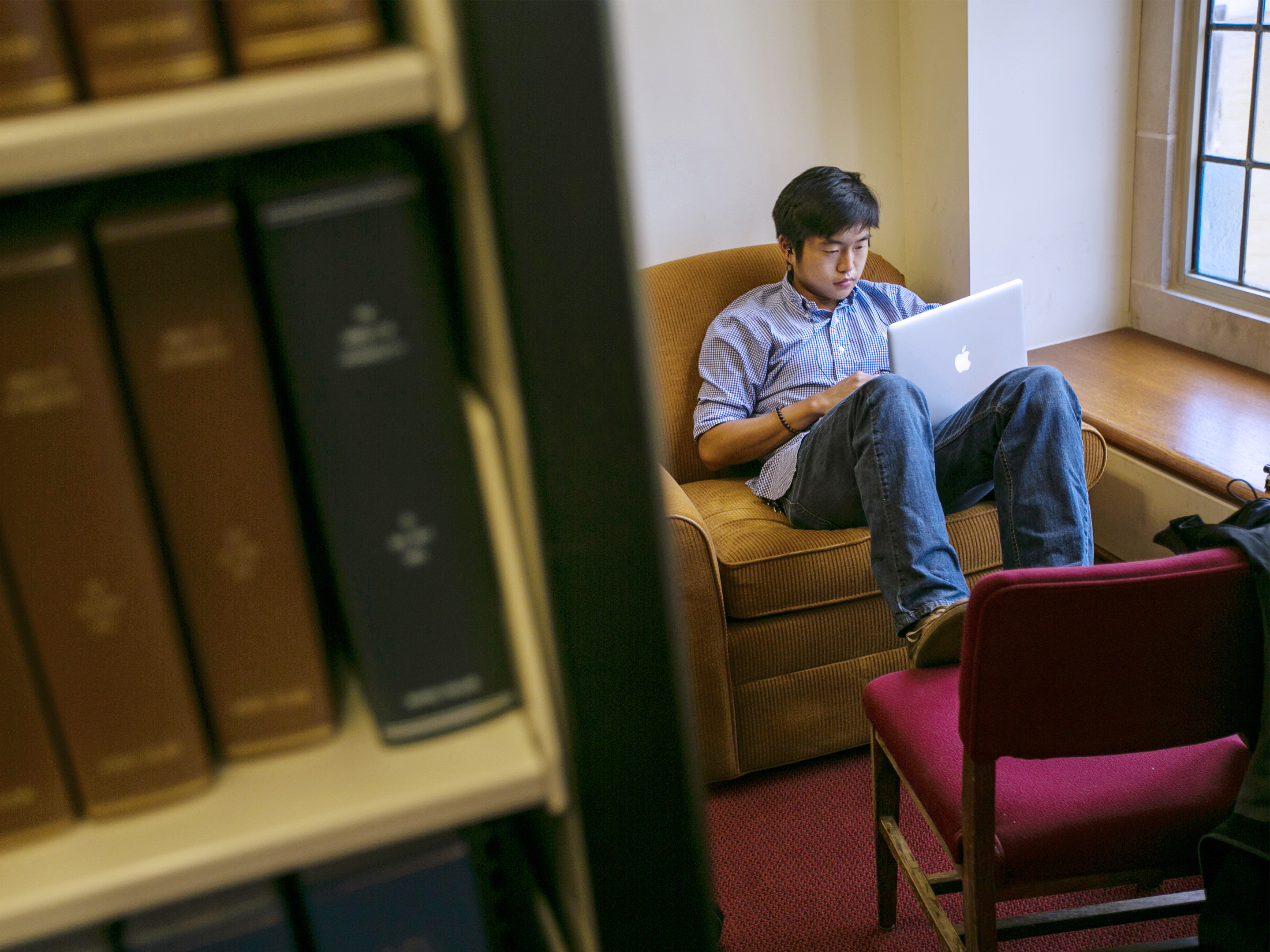 a student sitting with a laptop in the library